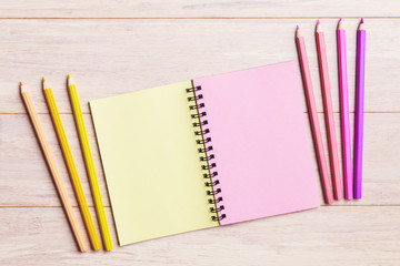 Obraz premium Open notebook with pink and yellow pencils