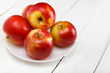 Красные яблоки на белом столе