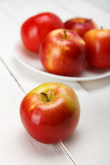 Красные яблоки на белом столе