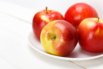 Красные яблоки на белом столе