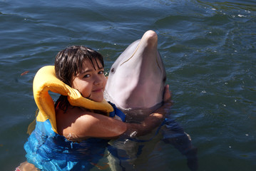 Girl is hugging a dolphin