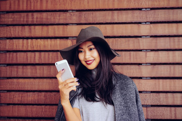 Young beautiful women lady touching and browsing her smart-phone on a wooden background