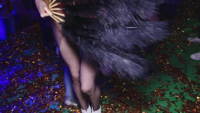 Energetic dance sexy girls in red and sexy booty. Cheerful and energetic art music fun dancing in motion feet legs of group people human men and women female in a disco in shoes of different colors. 