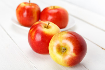 Свежие яблоки на белом деревянном столе