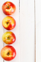 Свежие яблоки на белом деревянном столе