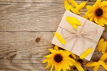 Decorative sunflowers and gift box on wooden table top view