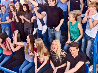 Fototapeta premium Sport young fans boy and girl clapping and singing on tribunes. Group people.