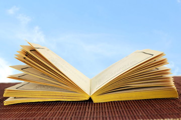 Open old book isolated on sky background