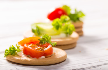 Cheese, tomatoes and greens on several cookies