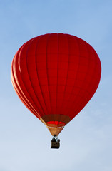 Naklejka premium A red hot-air balloon in the sky on a beautiful summer morning.