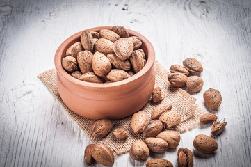 Almond nuts in bowl rustic wooden background
