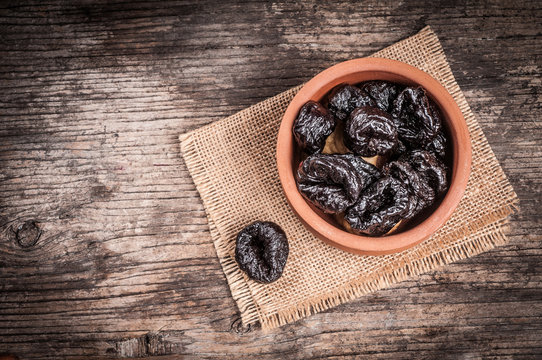 Dried plums in clay bowl 