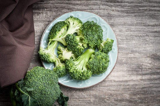 Full plate raw broccoli rustic wooden table