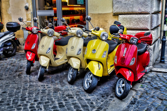 Scooters are parked on the city street in Rome, Italy
