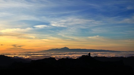 Vibrant sunset with Roque Nublo in foreground and Tenerife island in background, Canary islands 