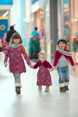 Girls sister walk along the mall, playing in  big store,