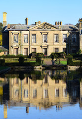 A photograph of Coombe Abbey hotel and its reflection in the waters of the grounds.