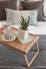 vase of plant and cup of coffee on wooden tray in modern bedroom