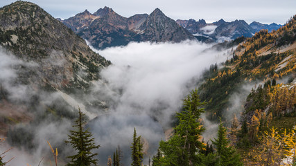 A small lake amidst the scenic autumn mountains shrouded in mist, HEATHER-MAPLE PASS LOOP TRAIL, Washington state