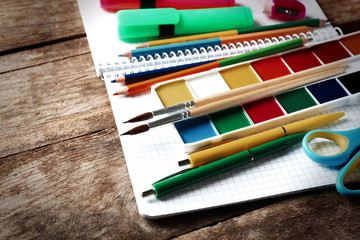 Naklejka premium Bright school stationery on old wooden table