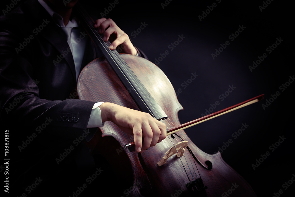 Wall mural Man playing on cello on dark background