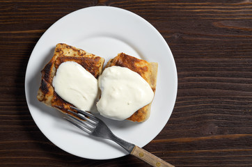 Fried pancakes with meat and sour cream