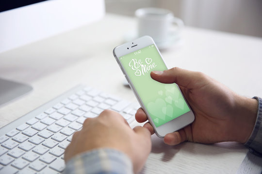 Young Businessman Using His Phone With Romantic Screensaver