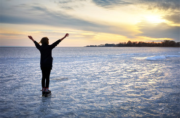 Fototapeta premium Girl on roller skates standing on a frozen lake 