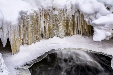 Water spills from the bottom of frozen Brownstone Falls in Copper Falls State Park, WIsconsin.