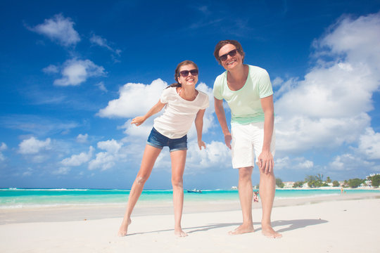 Closeup of happy young caucasian couple in sunglasses smiling on beach