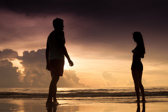 sunset silhouette of young couple in love at beach. sunset