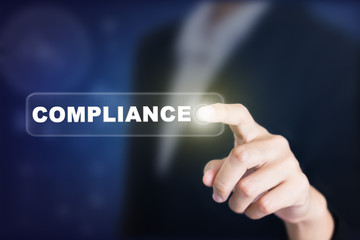 Businessman pressing a COMPLIANCE concept button. Can be used in advertising.