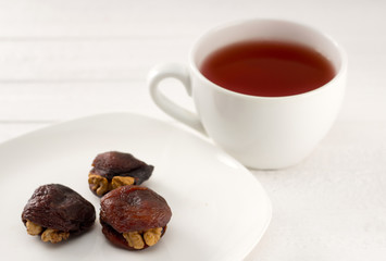 Three Hashtak (apricots with walnuts) and a cup of red tea with a flower