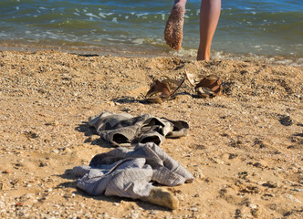 Sandals, clothers and legs os a beach