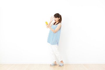 女性　スマートフォン持ち　驚く　リビング