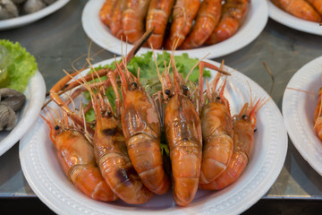 Grilled shrimp in foam dish at Thai night market. Street food.