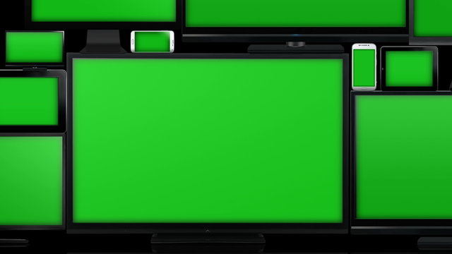 Many different types of screens. TVs, computer monitors, smartphones and tablets. They laid on each other in a pile isolated on a white background. They are all with a green screen. Zoom in & alpha