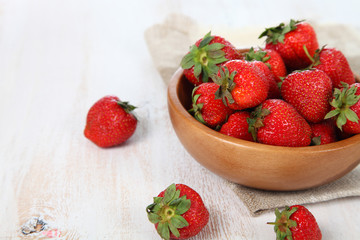 Ripe strawberries in a brown bowl