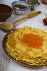 Pancakes with red caviar on a table.
