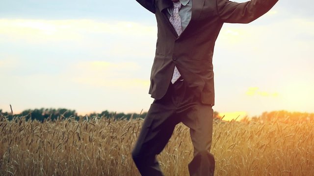 Happy businessman dancing in a field during sunset in slowmotion. 1920x1080