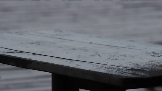 Clear raindrops falling down on wooden table. Sad and rainy weather, bad mood
