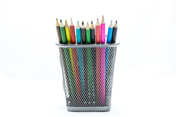 Colored crayons on the basket isolate on white background