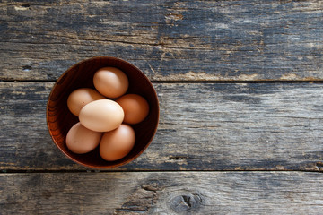egeggs in a wooden bowl on the table top view  