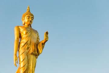 Fototapeta na wymiar Standing Buddha Statue In Blue Sky, public landmark located in C