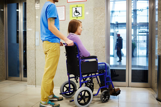 Guy and his girlfriend in wheelchair waiting for elevator