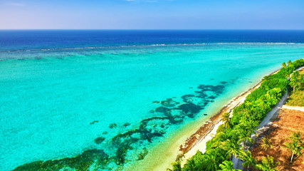 Shoreline of a tropical island in the Maldives and view of the I