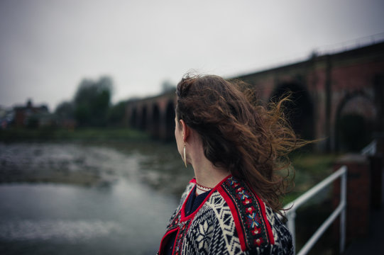 Young woman standing alone on bridge