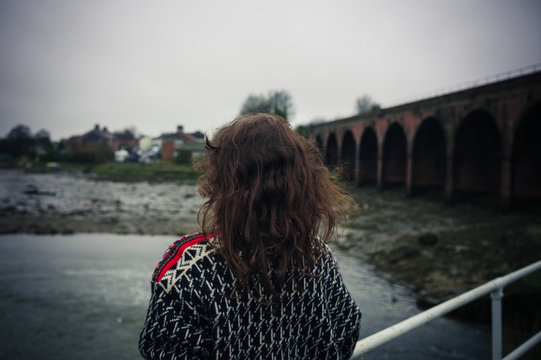 Young woman standing alone on bridge
