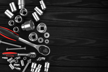 Set of wrenches, bolts and nuts on a wooden background.