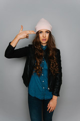 Portrait of cute teen girl isolated on gray studio background posing to the camera
